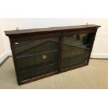A circa 1900 mahogany hanging wall display cabinet with two plain glazed doors enclosing four