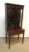An Edwardian mahogany display cabinet, the two glazed doors enclosing two shelves over a single