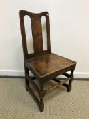 A late 18th / early 19th Century oak panel seated hall chair on turned and block legs united by