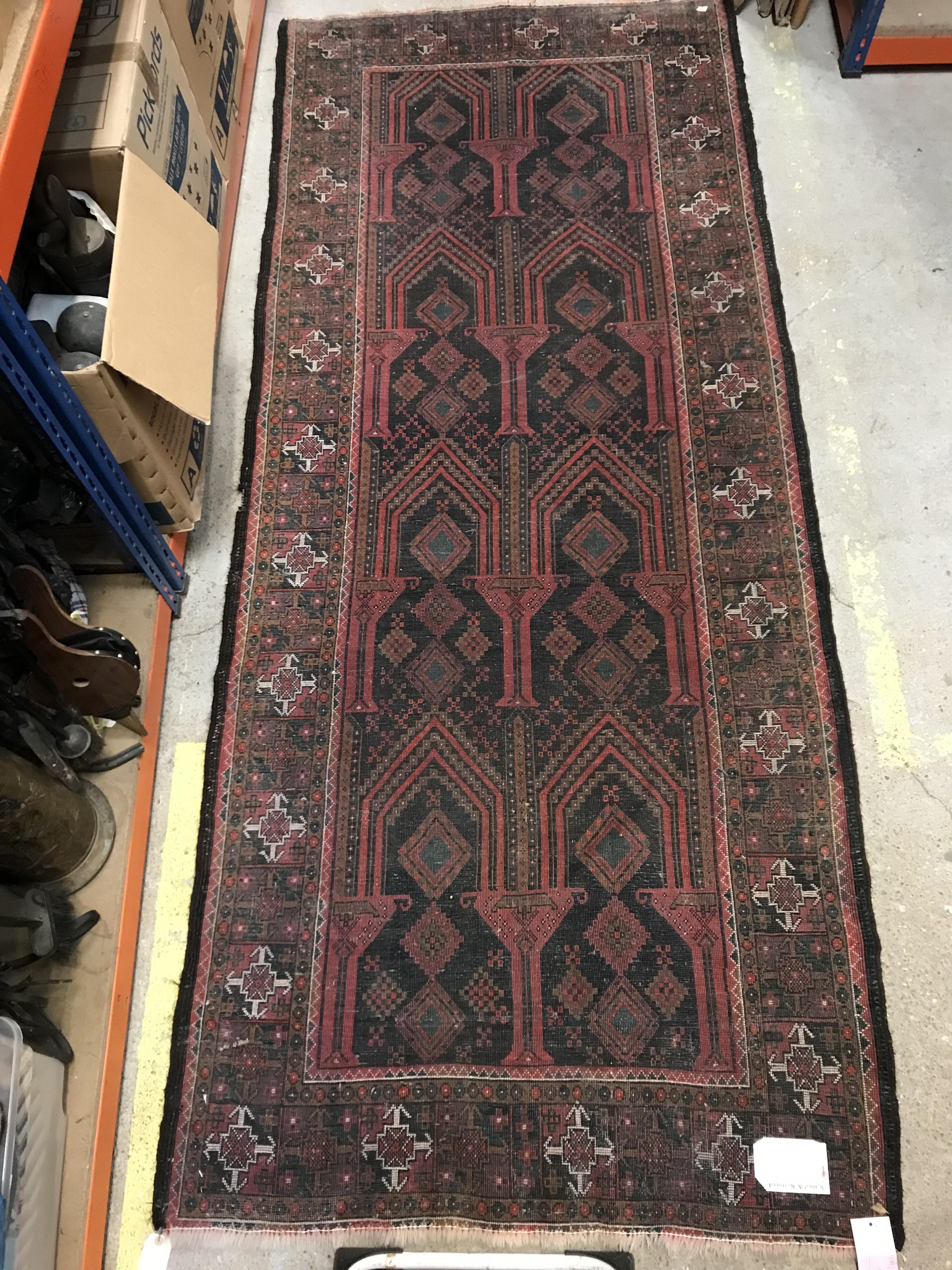 A Persian carpet, the central panel set with repeating arch decoration on a black and red ground, - Image 15 of 17