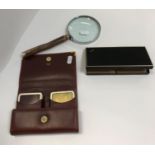 An Asprey black leather cigarette box with yellow metal mounts, a Cartier burgundy leather playing