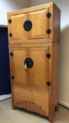 An Eastern blond elm cupboard with two small cupboard doors over two larger cupboard doors and