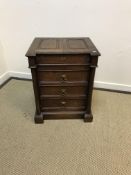 A Victorian oak chest with double fielded rising top over three drawers flanked by column supports