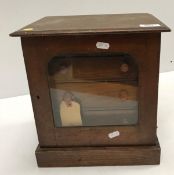 A circa 1900 stained pine collectors cabinet, the single glazed door enclosing three fitted