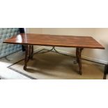 A modern Spanish style walnut dining table, the plank top with moulded edge on shaped end supports