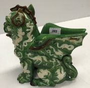 A green glazed pottery winged temple lion vase decorated in relief with dragons 25 cm high x 26 cm