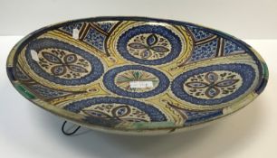 An Iznic type circular charger in blue and yellow with stylised floral design and a Chinese sang