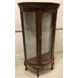 A modern stained beech framed demi lune vitrine in the French taste with carved decoration, the