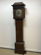 An oak cased long case clock, the caddy top with blind fretwork frieze over a plain main body, the