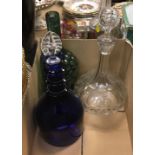 A box containing a collection of four decanters including a pair of green glass grape and vine