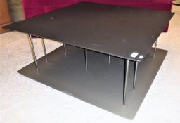 A Ligne Roset two tier coffee/book table, the ebonised top with chamfered edge raised on thirteen