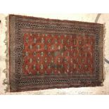 A Bokhara type carpet, the central panel set with repeating motifs on a rust red ground within a