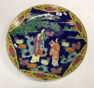 A modern Japanese charger decorated with figures in a landscape on a blue and yellow ground 47 cm in