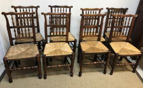 A set of ten North Country spindle back rush seated chairs on turned legs to pad and ball feet (