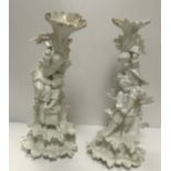 A pair of 19th Century Dresden blanc de chine candle holders, one as a couple of girls holding aloft