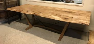 A modern refectory type dining table, the plank top of burred and rough edged form on splayed