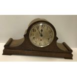 A large oak cased dome top mantel clock, the silvered dial with Arabic numerals together with an