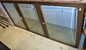 An oak display cabinet with two bevel edged plate glazed doors flanking a central matching panel 178