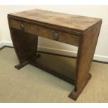 A 1930s Art Deco walnut two drawer writing table with chrome knob handles raised on tapering plank