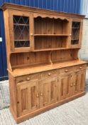A modern pine dresser, the plate rack with two leaded glazed doors over four drawers and four twin