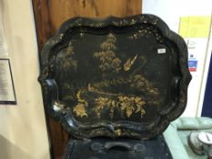 A Victorian black lacquered and japanned papier-mache tray with pie crust rim, the centre field