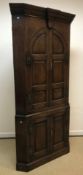 A late 18th/early 19th Century oak free standing corner cupboard with two arched fielded panelled