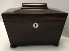 An early 19th Century rosewood sarcophagus shaped two section tea caddy on squat bun feet 22.5cm