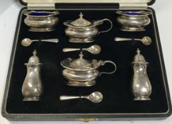 Two cased pairs of three piece silver cruets comprising pepper, lidded mustard and salt with