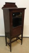 An Edwardian mahogany and barber pole strung display cabinet with raised back over a single part
