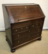 An 18th Century oak bureau, the plain top above a sloping fall with fitted interior and well over