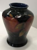 A Moorcroft pomegranate design vase of flared form 19 cm high