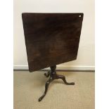 An early 19th Century mahogany tea table, the rectangular snap top on a turned pedestal to