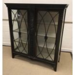 An Edwardian mahogany and carved display cabinet with scrolling foliate decoration, the two glazed