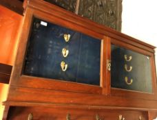 A circa 1900 walnut glazed two door wall mounted gun cabinet (non-compliant with current