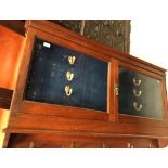 A circa 1900 walnut glazed two door wall mounted gun cabinet (non-compliant with current