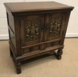 A 20th Century oak dwarf cupboard in the 17th Century manner, the plain top above two armorial