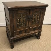 A 20th Century oak dwarf cupboard in the 17th Century manner, the plain top above two armorial