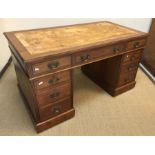 An Edwardian mahogany pedestal desk, the plain top above two banks of four drawers with central