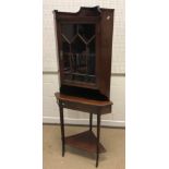 An Edwardian mahogany corner cupboard with glazed door enclosing a single shelf, raised on a plain