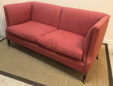 A circa 1900 upholstered high back two seat sofa on square tapered legs to brass caps and castors by