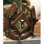 An early 20th Century carved oak wall mirror / coat hook in the form of a horse shoe, 69 cm x 56 cm