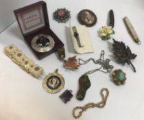 A bag of assorted costume jewellery to include various brooches, pendants, collar studs, etc,