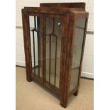 A 1930's Art Deco style walnut display cabinet with two doors enclosing glass shelving, 88 cm wide x