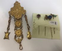 A gilt metal chatelaine with flower and ribbon decoration and four tie pins