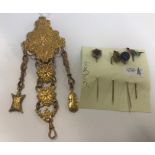 A gilt metal chatelaine with flower and ribbon decoration and four tie pins