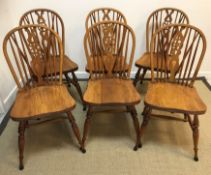 A set of six modern oak wheel and stick-back dining chairs