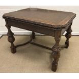 A mid 20th Century oak draw leaf dining table in the 17th Century style, the top with carved edge,