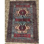 A Persian rug, the central panel set with mirrored geometric design on a blue ground, within a