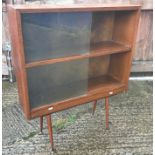 A 1960's oak display cabinet with two pairs of sliding glass doors, raised on splayed turned