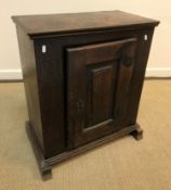 An 18th Century Dutch oak dwarf cupboard, the fielded panelled door enclosing a single shelf, raised